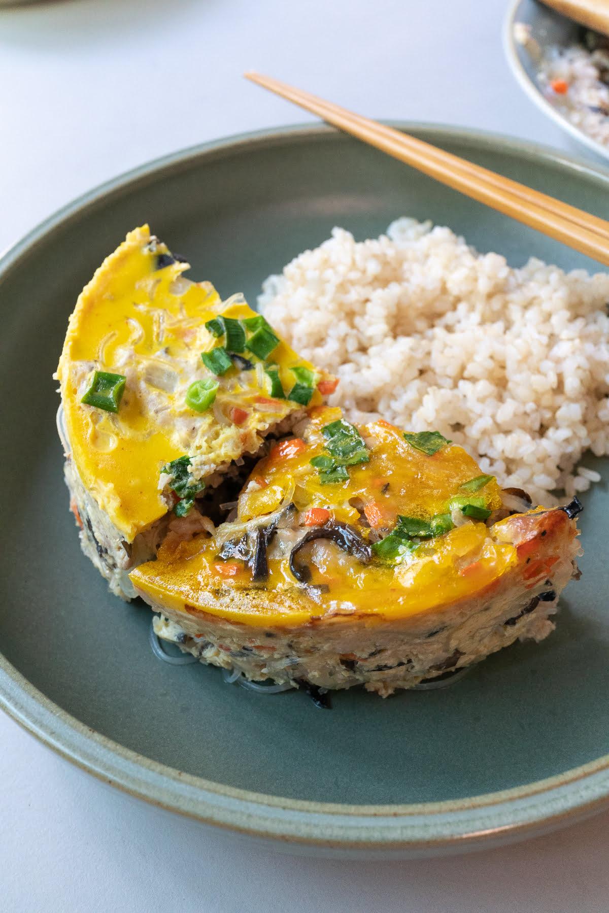 Wedges of baked and steamed Vietnamese Egg Meatloaf (Cha Trung) served with rice.